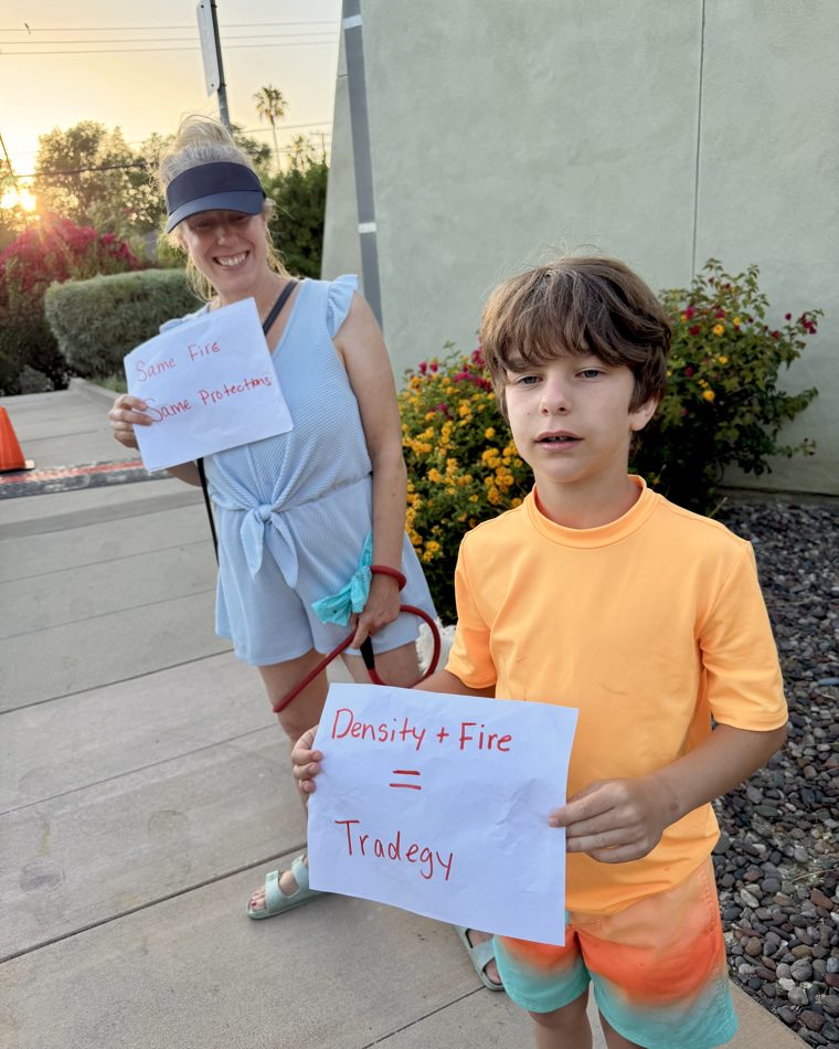Altadena kids hold 'Density + Fire = Tragedy' signs at a community rally.